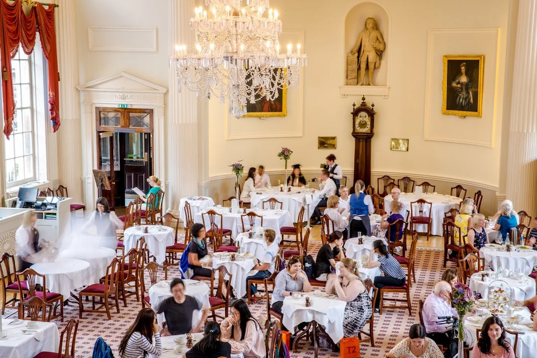 The elegant Georgian interior of The Pump Room Restaurant in Bath, with chandeliers and tables set for afternoon