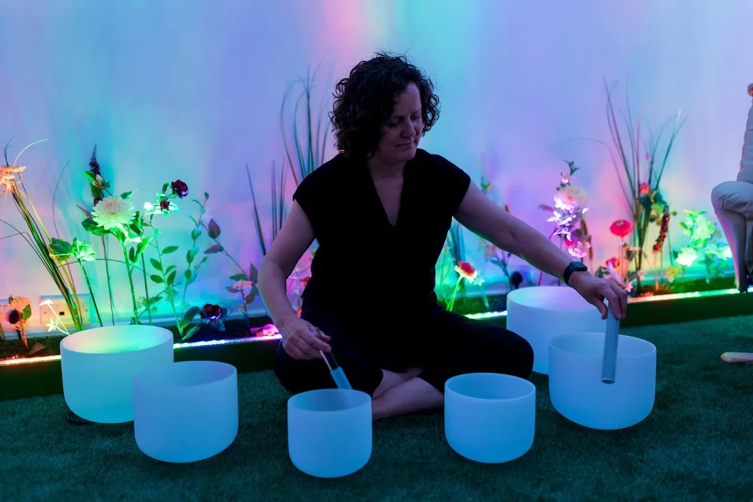 A tranquil room at The Soul Spa during a sound bath session, with people relaxing on mats.