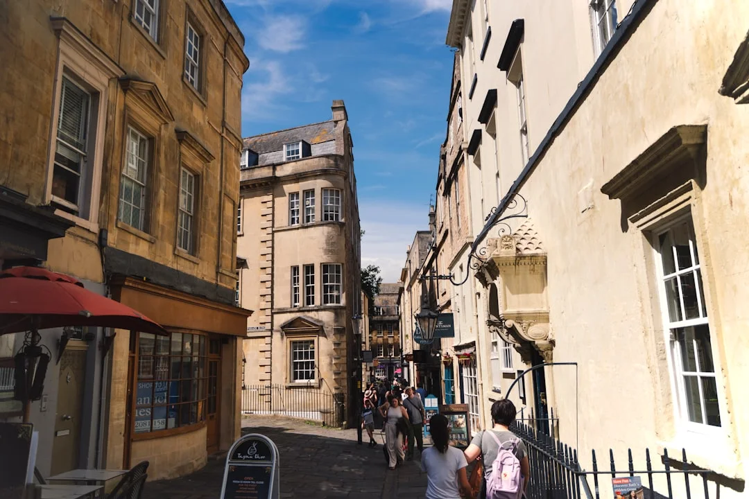 Steep cobbled street in Bath, lined with historic Georgian buildings and pedestrians